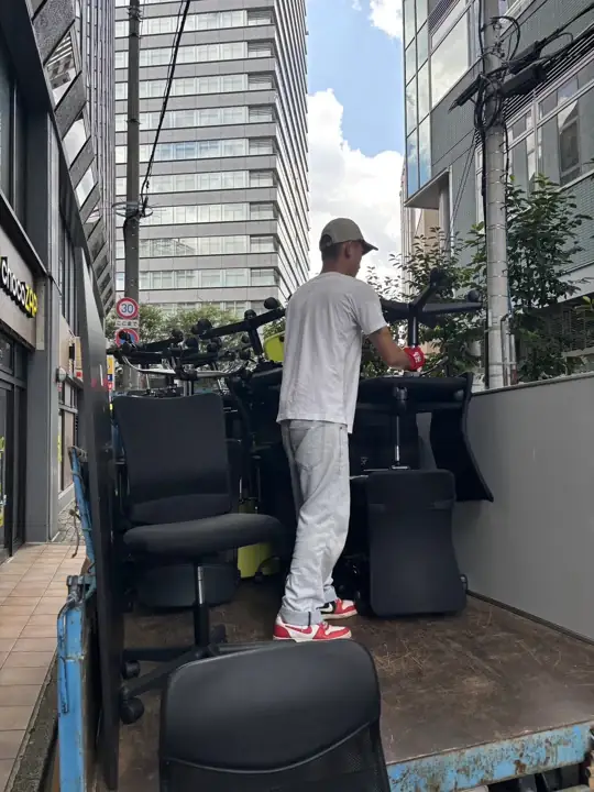 仙台市青葉区本町のオフィス家具回収事例:搬出したオフィスチェアをトラックの荷台に積み込む作業の様子