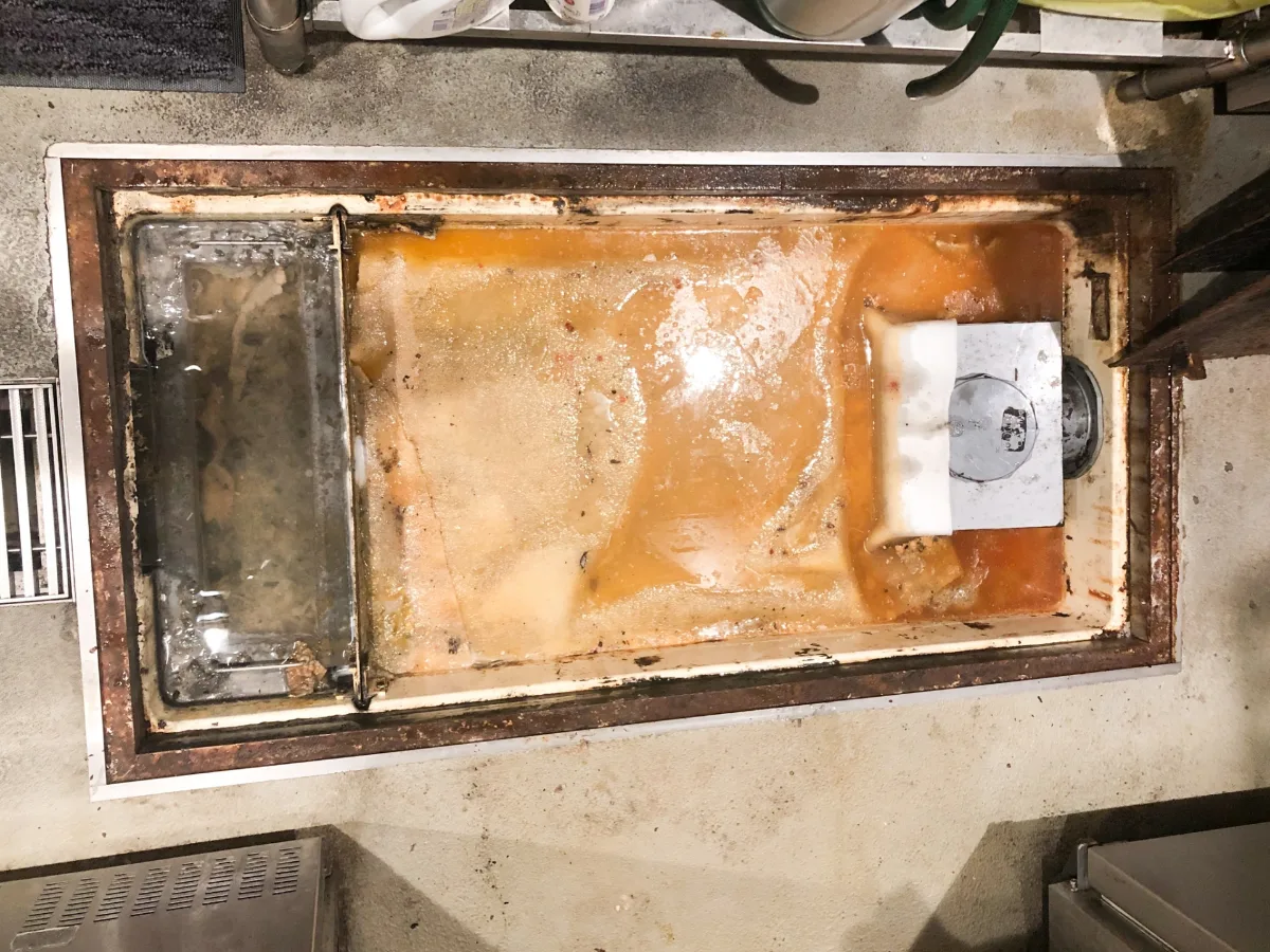 油や汚れがたまった飲食店のグリストラップ